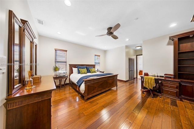 bedroom with ceiling fan, built in desk, and hardwood / wood-style floors