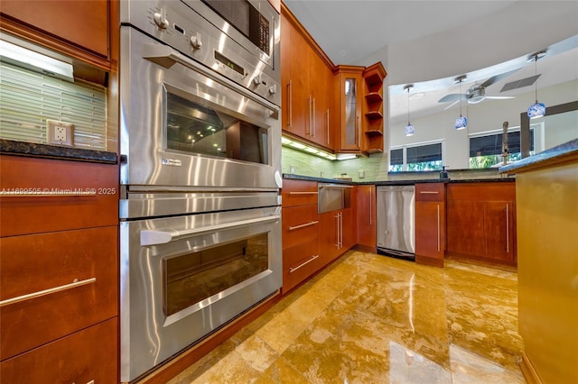 kitchen featuring ceiling fan, backsplash, dark stone countertops, pendant lighting, and appliances with stainless steel finishes