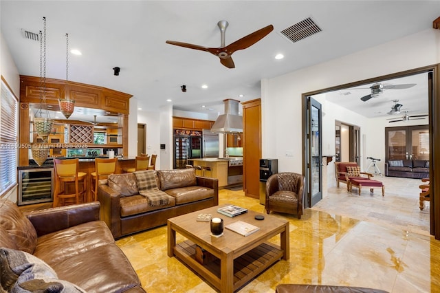 living room featuring ceiling fan, beverage cooler, and french doors