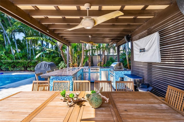 exterior space featuring ceiling fan, an outdoor kitchen, a bar, and area for grilling