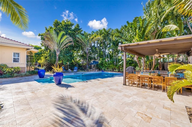 view of swimming pool with ceiling fan and a patio