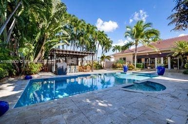 view of pool with a patio area, an in ground hot tub, and a pergola