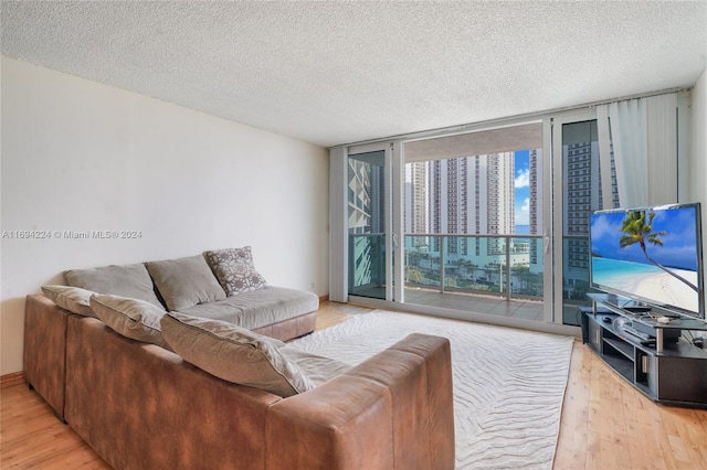 living room with expansive windows, wood-type flooring, and a textured ceiling