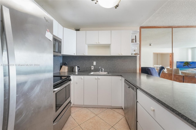 kitchen featuring appliances with stainless steel finishes, tasteful backsplash, white cabinetry, and sink