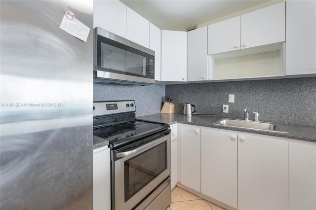 kitchen with sink, white cabinets, stainless steel appliances, and light tile patterned floors