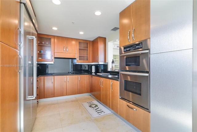 kitchen with light tile patterned flooring, stainless steel appliances, and sink