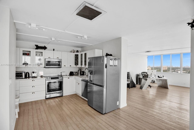 kitchen with white cabinetry, ceiling fan, stainless steel appliances, light hardwood / wood-style floors, and decorative backsplash