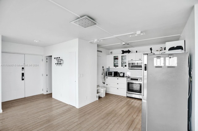 kitchen featuring light wood-type flooring, stainless steel appliances, and white cabinetry