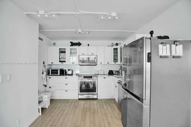 kitchen featuring decorative backsplash, light hardwood / wood-style floors, white cabinetry, and stainless steel appliances