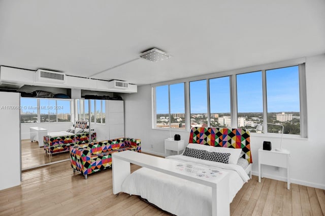 bedroom featuring multiple windows and light hardwood / wood-style flooring