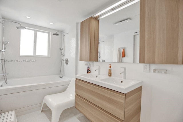 bathroom with tile patterned floors, vanity, and tiled shower / bath