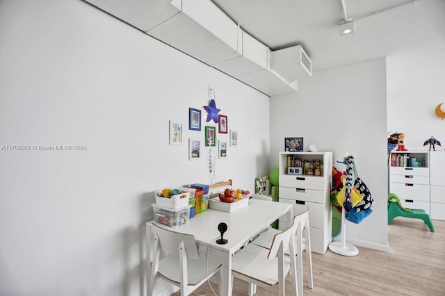 dining space with rail lighting and light hardwood / wood-style floors