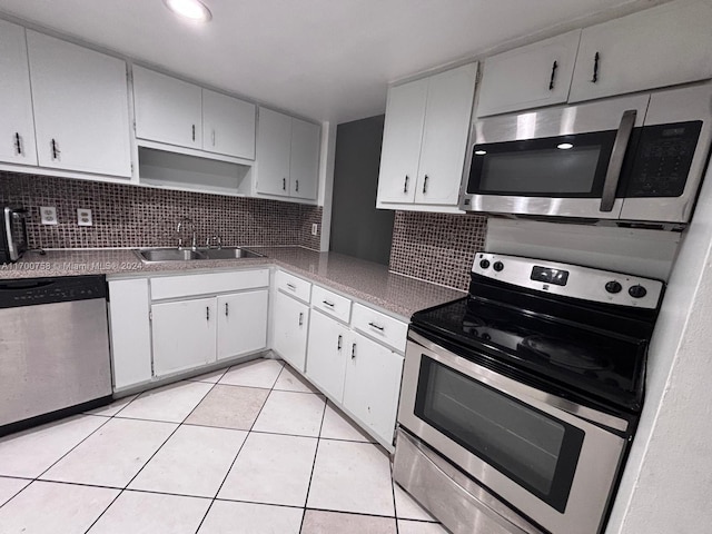 kitchen with white cabinetry, sink, backsplash, light tile patterned floors, and appliances with stainless steel finishes