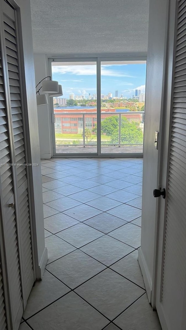 hall with light tile patterned floors and a textured ceiling