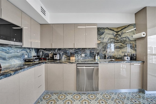 kitchen featuring decorative backsplash, appliances with stainless steel finishes, and dark stone counters