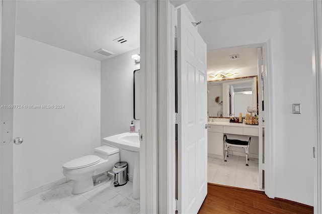 bathroom featuring wood-type flooring and toilet