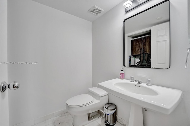 bathroom with toilet and tile patterned floors