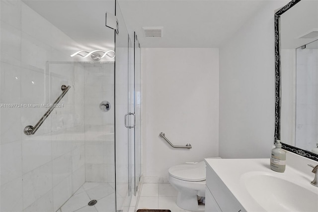 bathroom featuring tile patterned floors, vanity, toilet, and an enclosed shower