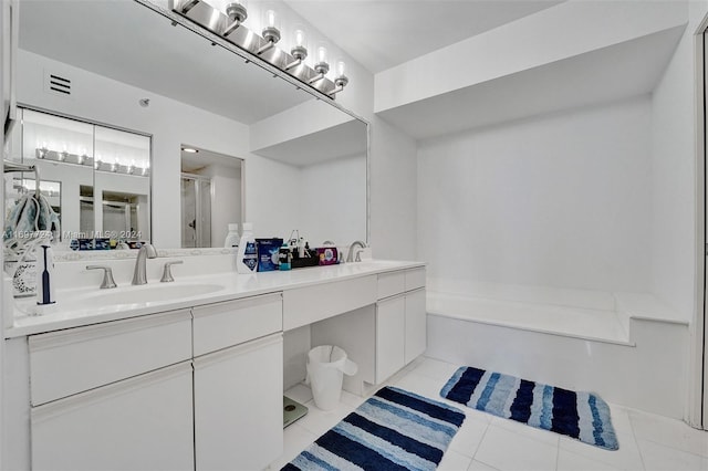 bathroom with tile patterned floors, vanity, and shower with separate bathtub