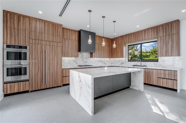 kitchen featuring premium range hood, stainless steel double oven, sink, hanging light fixtures, and a large island