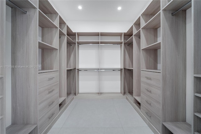 walk in closet with light tile patterned floors