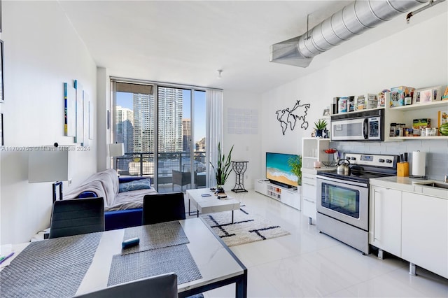 kitchen featuring backsplash, white cabinets, and appliances with stainless steel finishes