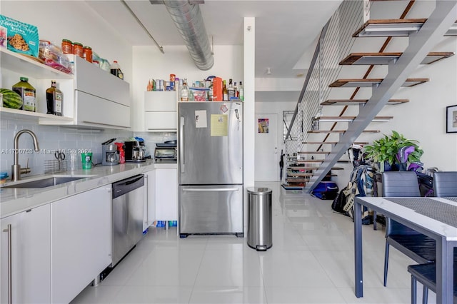 kitchen with white cabinetry, sink, light tile patterned flooring, and appliances with stainless steel finishes