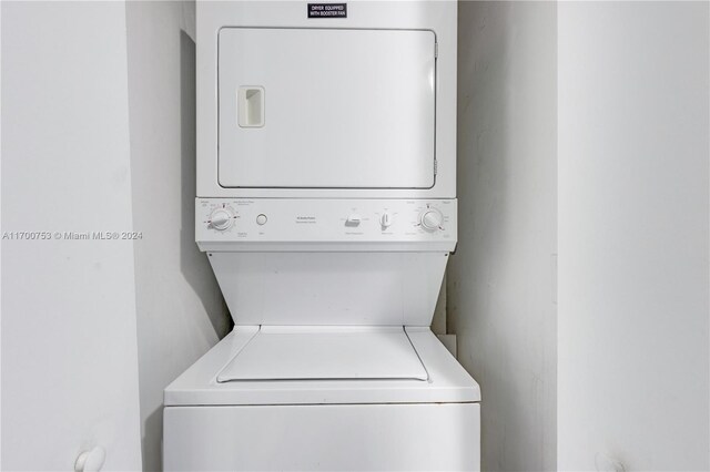 clothes washing area featuring stacked washer and clothes dryer