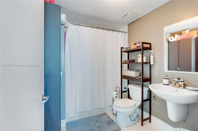 bathroom featuring tile patterned floors, a shower with curtain, and toilet