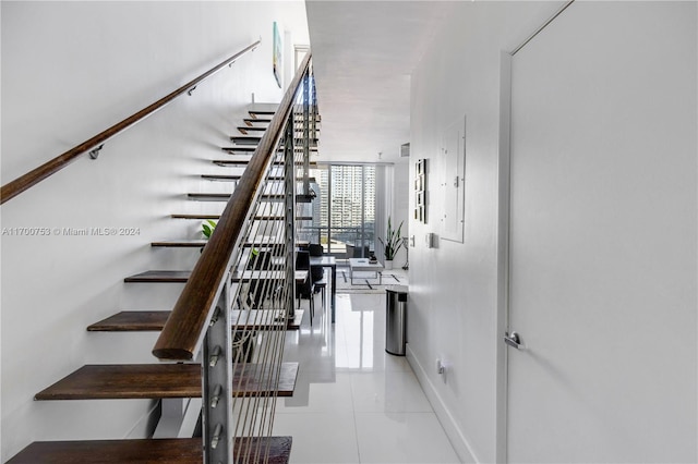 stairs featuring tile patterned flooring and electric panel