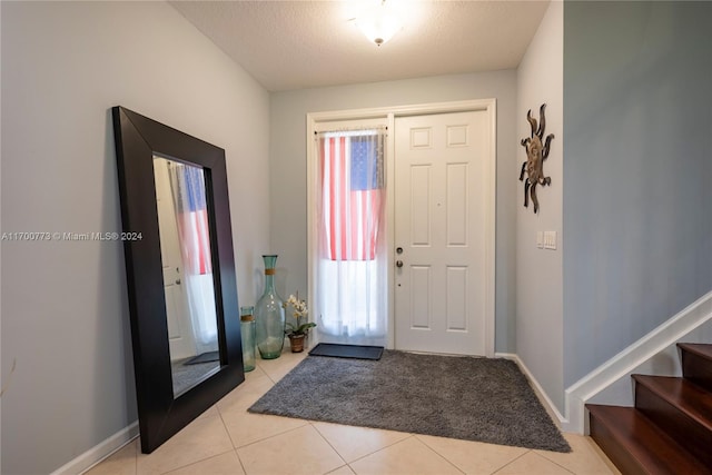 entrance foyer featuring light tile patterned floors and a textured ceiling