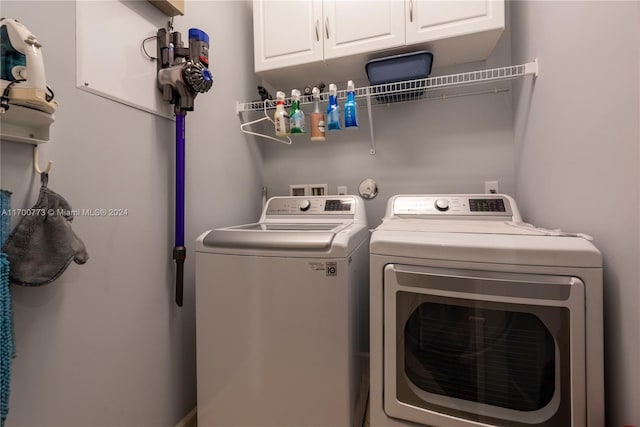 laundry area with cabinets and washing machine and clothes dryer