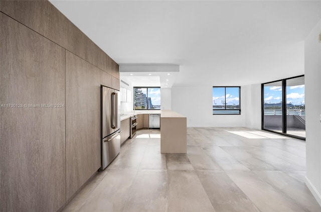 kitchen featuring appliances with stainless steel finishes, expansive windows, and light brown cabinetry