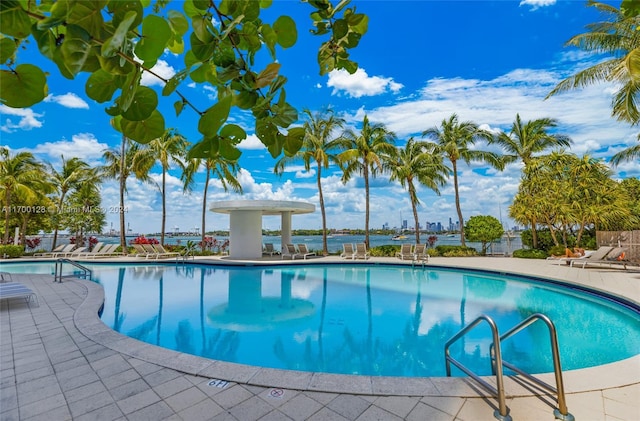 view of pool with a patio area and a water view