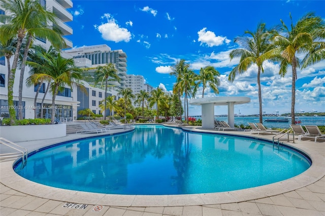 view of pool with a water view and a patio