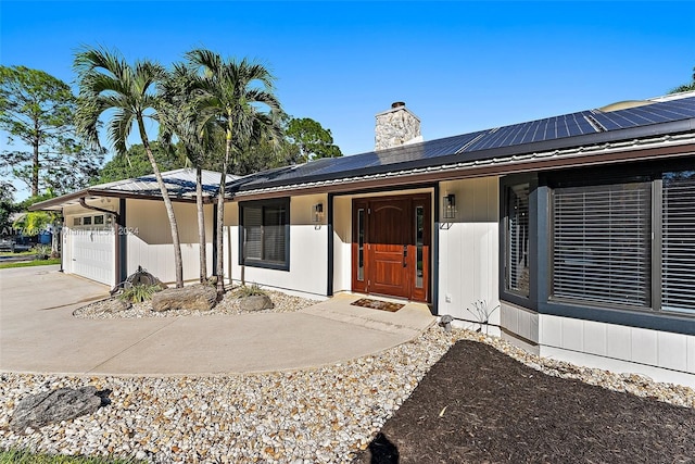 view of front of home featuring solar panels, covered porch, and a garage