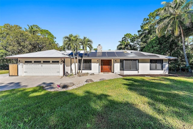 ranch-style house with solar panels, a garage, and a front lawn