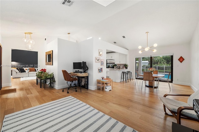 interior space with light hardwood / wood-style floors, vaulted ceiling, and a notable chandelier