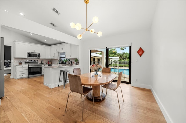 dining space featuring light hardwood / wood-style floors, vaulted ceiling, and a notable chandelier