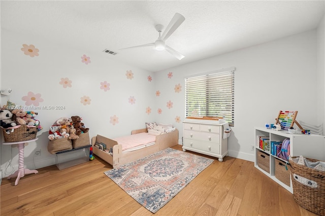 bedroom featuring a textured ceiling, light hardwood / wood-style floors, and ceiling fan