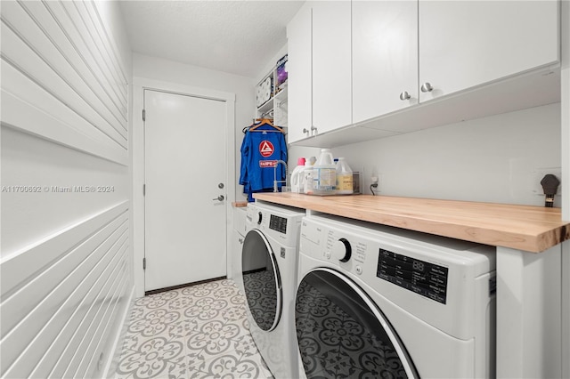 washroom featuring washer and clothes dryer and cabinets