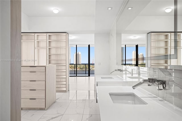 kitchen featuring backsplash, light brown cabinetry, and sink