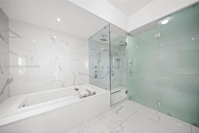 bathroom with shower with separate bathtub and tile walls