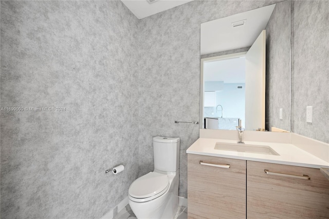 bathroom featuring tile patterned flooring, vanity, and toilet