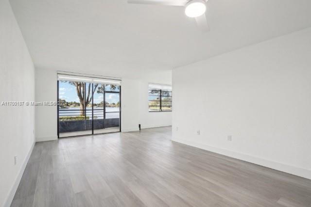 unfurnished room with ceiling fan and hardwood / wood-style flooring