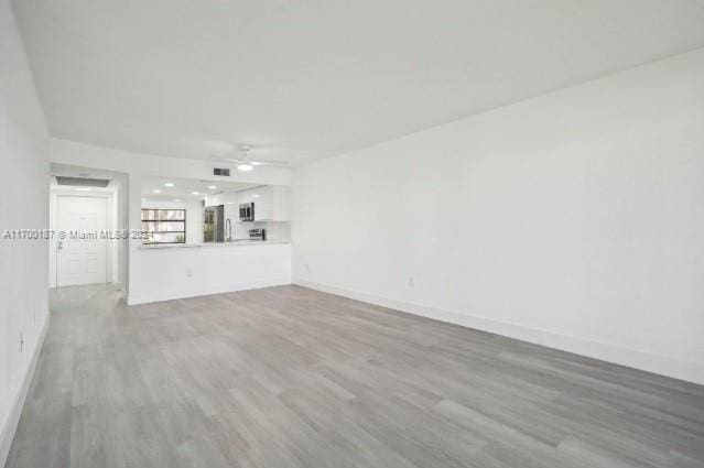 unfurnished living room featuring light hardwood / wood-style floors and ceiling fan