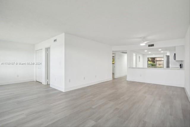 unfurnished living room with ceiling fan and light hardwood / wood-style floors