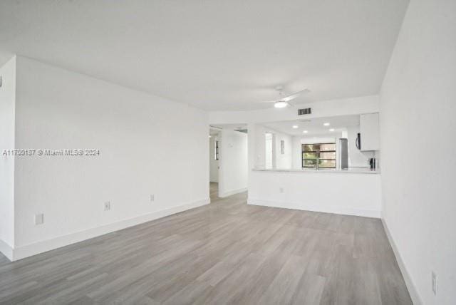 unfurnished living room with ceiling fan and light hardwood / wood-style flooring