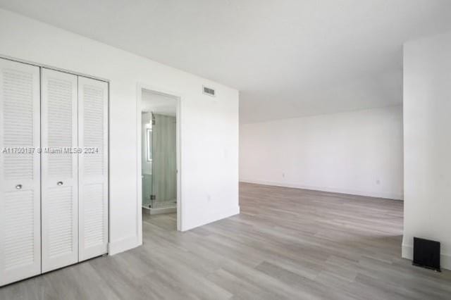 unfurnished bedroom featuring light wood-type flooring and a closet