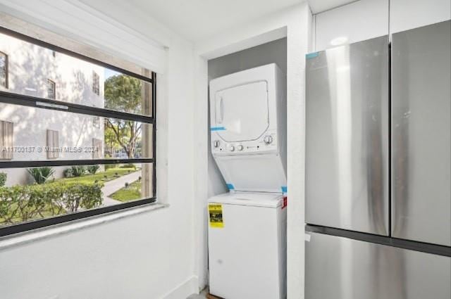 laundry room with stacked washer / drying machine and plenty of natural light